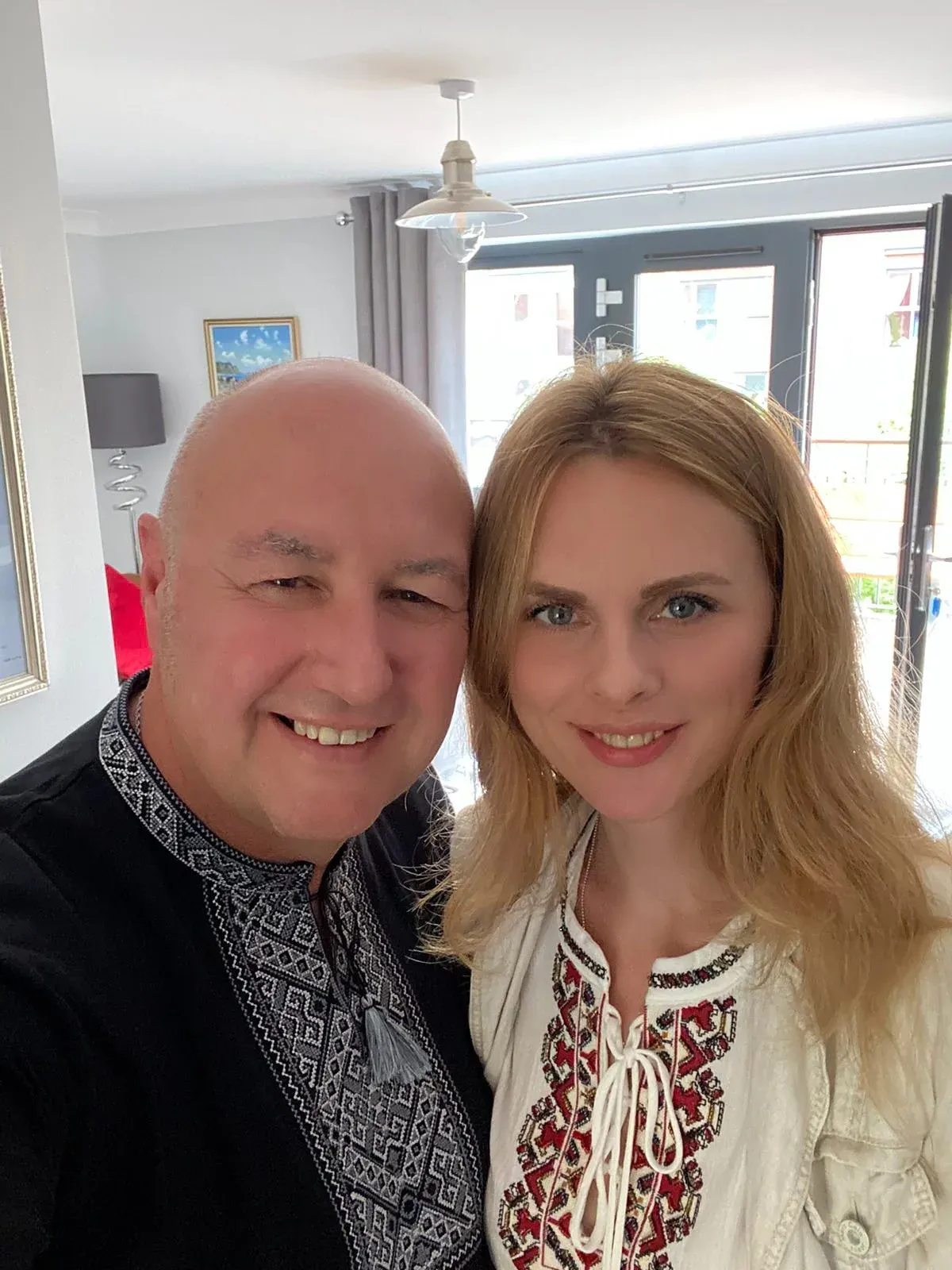 Gary and Elena smiling together indoors.